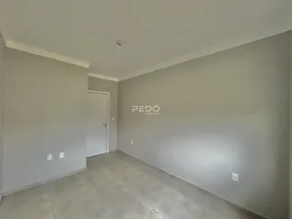 Vista interna de um ambiente com paredes claras e piso de cerâmica.