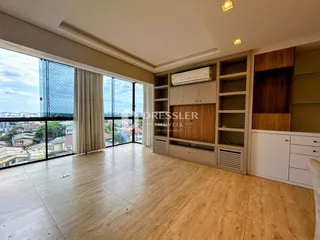 A sala de estar possui piso de madeira e grandes janelas com vista para a paisagem.