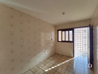 Interior de um cômodo com paredes brancas e piso de cerâmica.