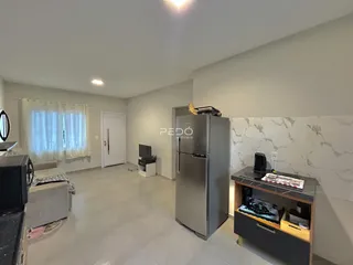 Sala de estar com piso de cerâmica e paredes claras.