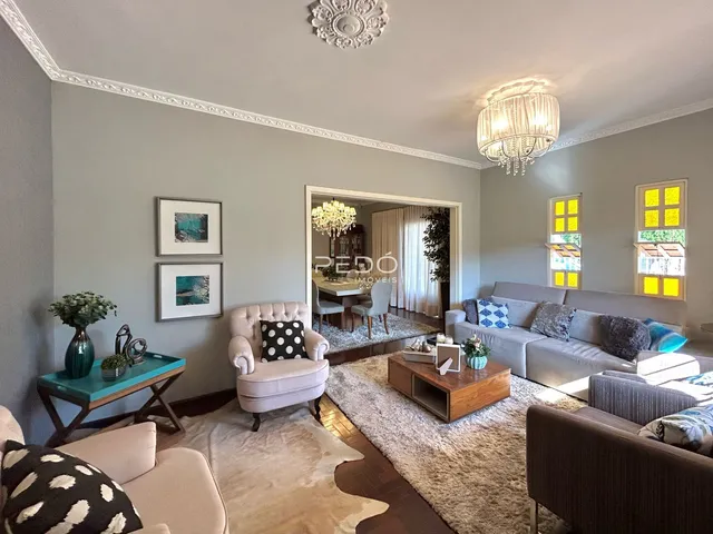 Sala de estar ampla com piso de madeira e decoração clássica.