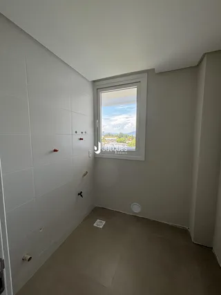Corredor interno com paredes brancas e janela de vista para a paisagem.