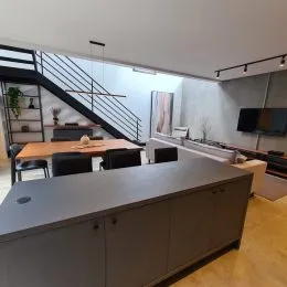 Cozinha moderna com ilha central e armários cinzas.