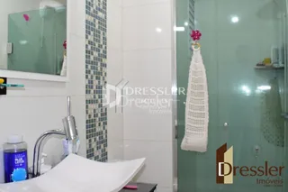 Foto de um banheiro com azulejos e box de vidro.