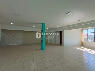 Ambiente interno de uma sala com piso de cerâmica clara e paredes brancas.