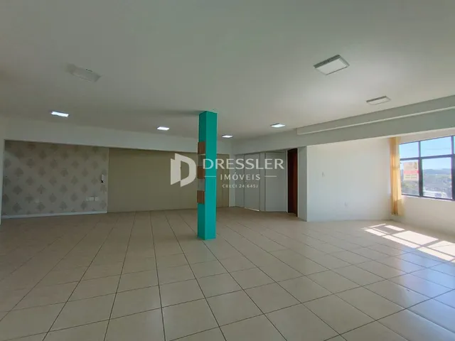 Ambiente interno de uma sala com piso de cerâmica clara e paredes brancas.