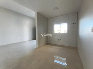 Ambiente interno de uma sala com piso de cerâmica e parede de tijolos brancos.