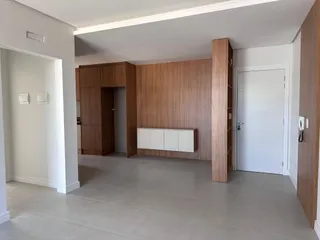 Sala de estar com painéis de madeira e piso claro.