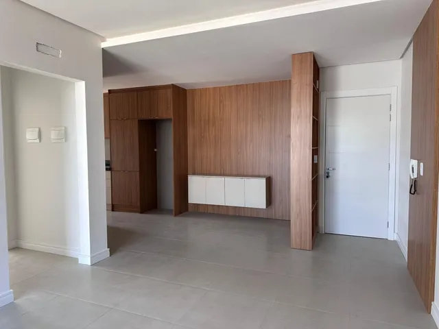 Sala de estar com painéis de madeira e piso claro.