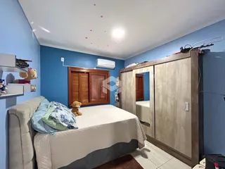 Quarto com armário de madeira e cama.