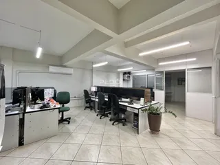 ambiente de escritório moderno com mesas e cadeiras em um imóvel.