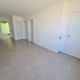 Foto de um ambiente interno com paredes brancas e piso claro.
