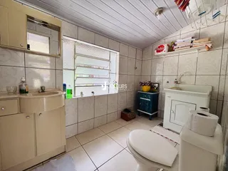 Foto de um banheiro com revestimento cerâmico e piso claro.