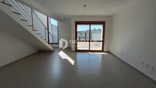 Hall de entrada com escada e porta de vidro.
