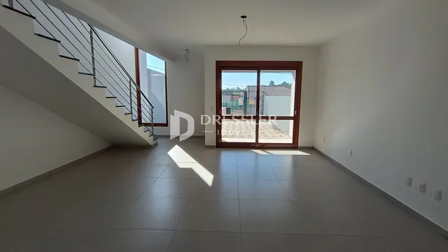 Hall de entrada com escada e porta de vidro.