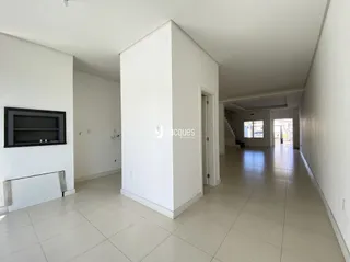 Corredor interno de uma residência com piso de cerâmica clara.
