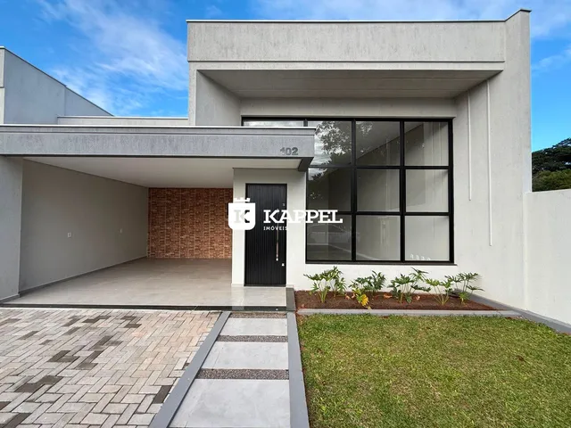 Fachada externa de uma casa moderna com revestimento branco e jardim na frente.