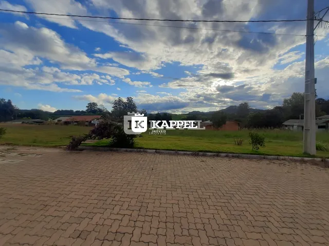 Vista externa de uma propriedade com campo gramado e paisagem de colinas.