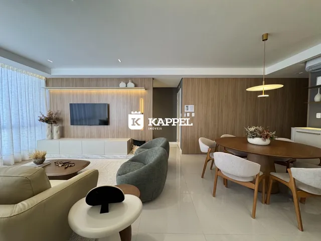 Sala de estar moderna com sofá e área de jantar em um apartamento.