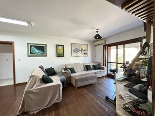 Sala de estar com piso de madeira e sofá.