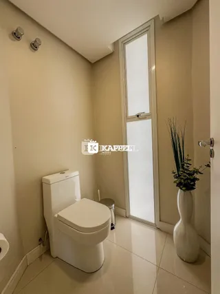 Foto de um banheiro interno com vaso sanitário branco e piso claro.