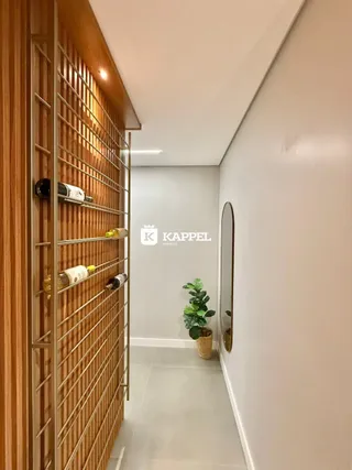 Hall de entrada com estante de madeira e parede branca.