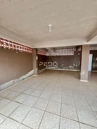 Interior de um espaço com piso de cerâmica e teto de concreto aparente.