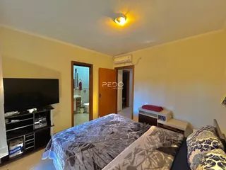 Quarto com cama e rack de televisão.