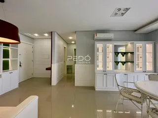 Ambiente interno de uma sala de estar com cozinha integrada em Lajeado.
