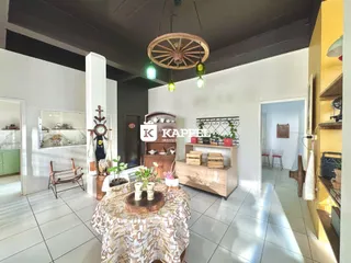 Uma sala de estar com piso de cerâmica e iluminação rústica pendurada no teto.