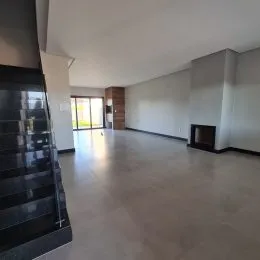 Vista de um espaço interno amplo com piso claro e paredes brancas.