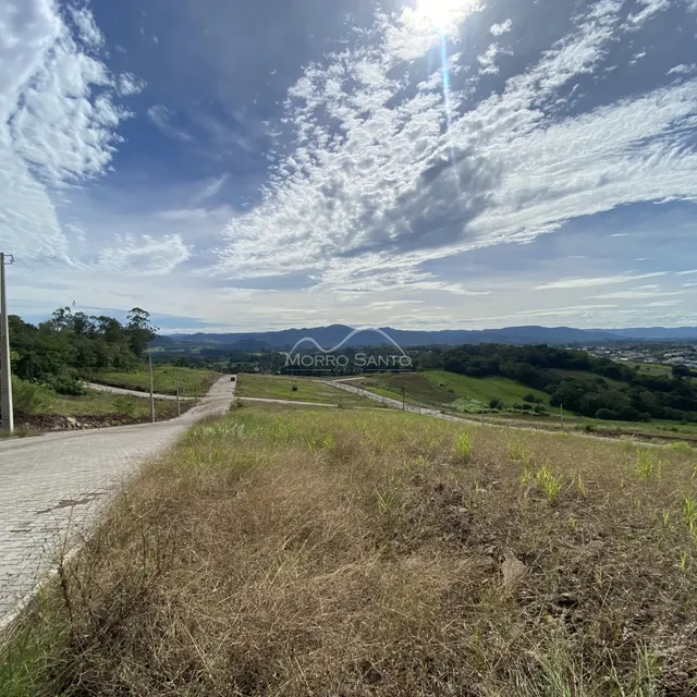 Vista panorâmica de uma paisagem rural com colinas verdes ao fundo.