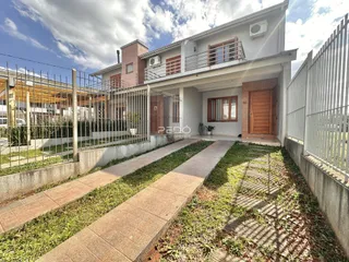 Fachada de uma residência em Lajeado, Brasil, com cerca e jardim na frente.