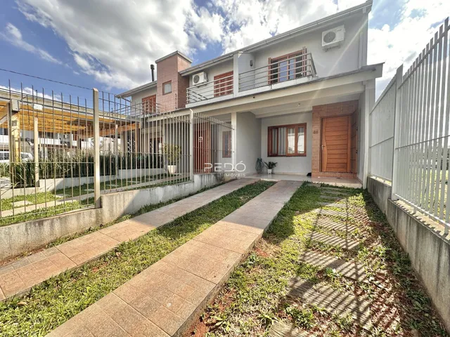 Fachada de uma residência em Lajeado, Brasil, com cerca e jardim na frente.