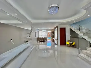 Sala de estar com piso de porcelanato e teto alto.