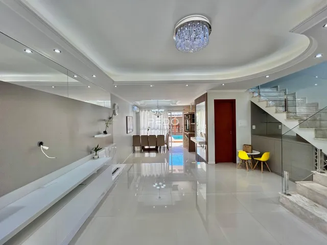 Sala de estar com piso de porcelanato e teto alto.