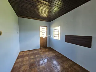 Ambiente interno com piso de cerâmica marrom e teto de madeira.