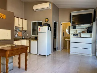 Cozinha com armários brancos e piso de cerâmica.