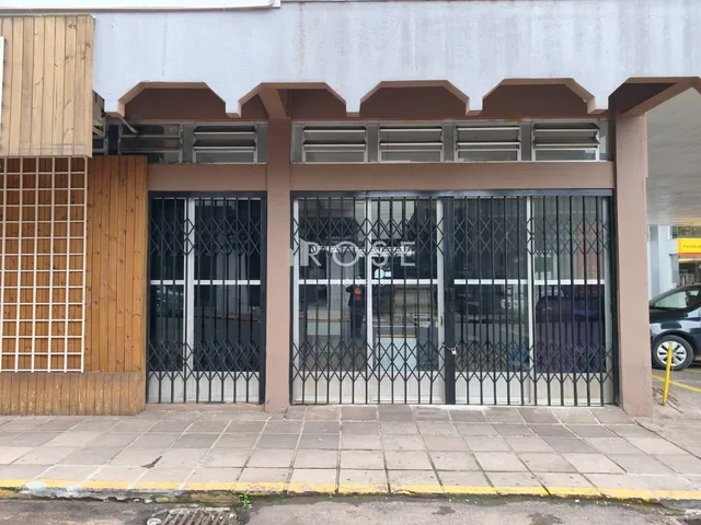 Fachada de um imóvel em Lajeado, Brasil, com portão de ferro e detalhes de madeira.