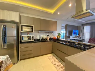 Cozinha moderna com armários de madeira clara e bancadas escuras.