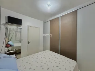 Quarto interno com cama e armários em um ambiente claro.