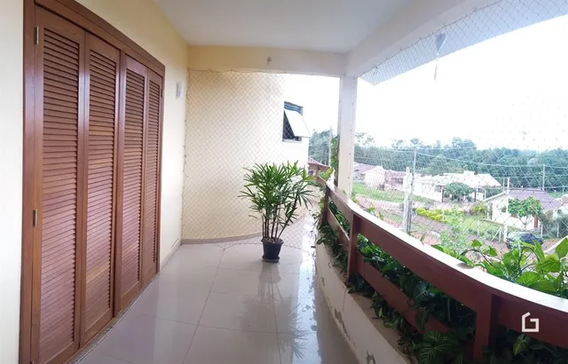 Interior de um ambiente com vista para uma área externa através de uma sacada.