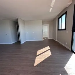 Ambiente interno com piso de madeira e paredes claras.