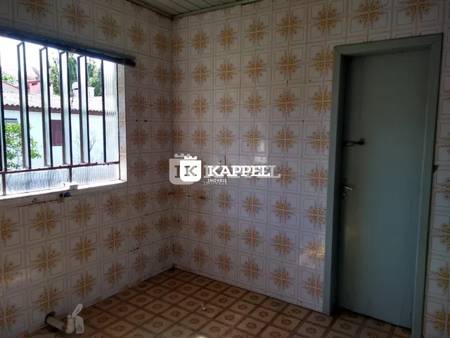 Foto interna de um cômodo com papel de parede estampado e piso de cerâmica.