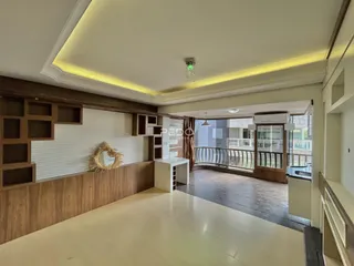 Ambiente interno de uma sala com painéis de madeira e vista para a área externa.