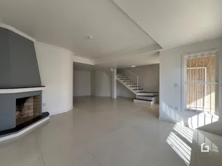 Ambiente interno de uma sala de estar com piso de cerâmica e lareira em Lajeado, Brasil.