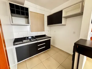Foto de uma cozinha com bancada escura e armários modernos.