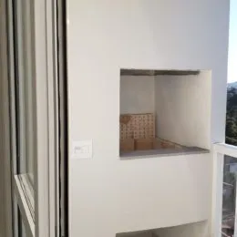 Uma parede branca com um nicho embutido é visível na propriedade.