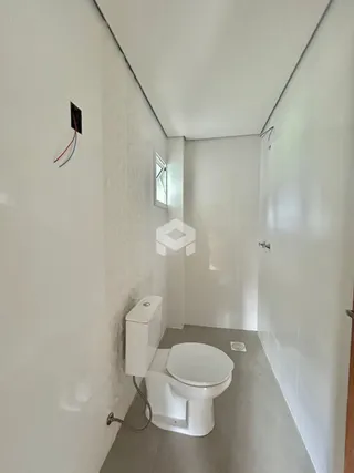 Foto de um corredor interno com um vaso sanitário branco.