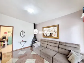 Sala de estar com sofá grande e lareira em ambiente claro.
